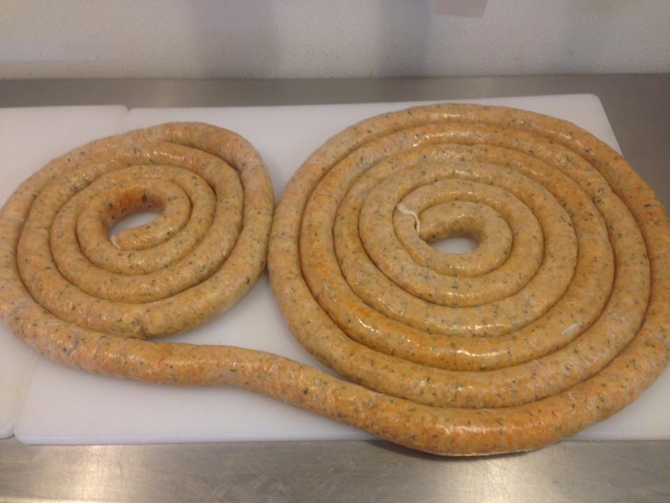 Two spirals of sausage are sitting on a cutting board.
