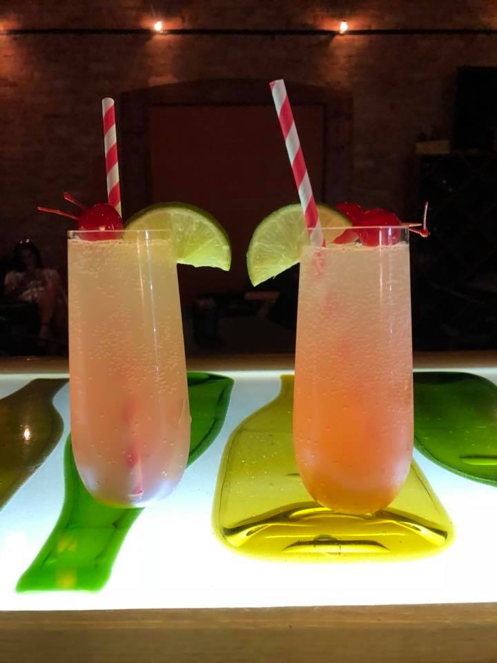 Two drinks with straws and lime slices on a table