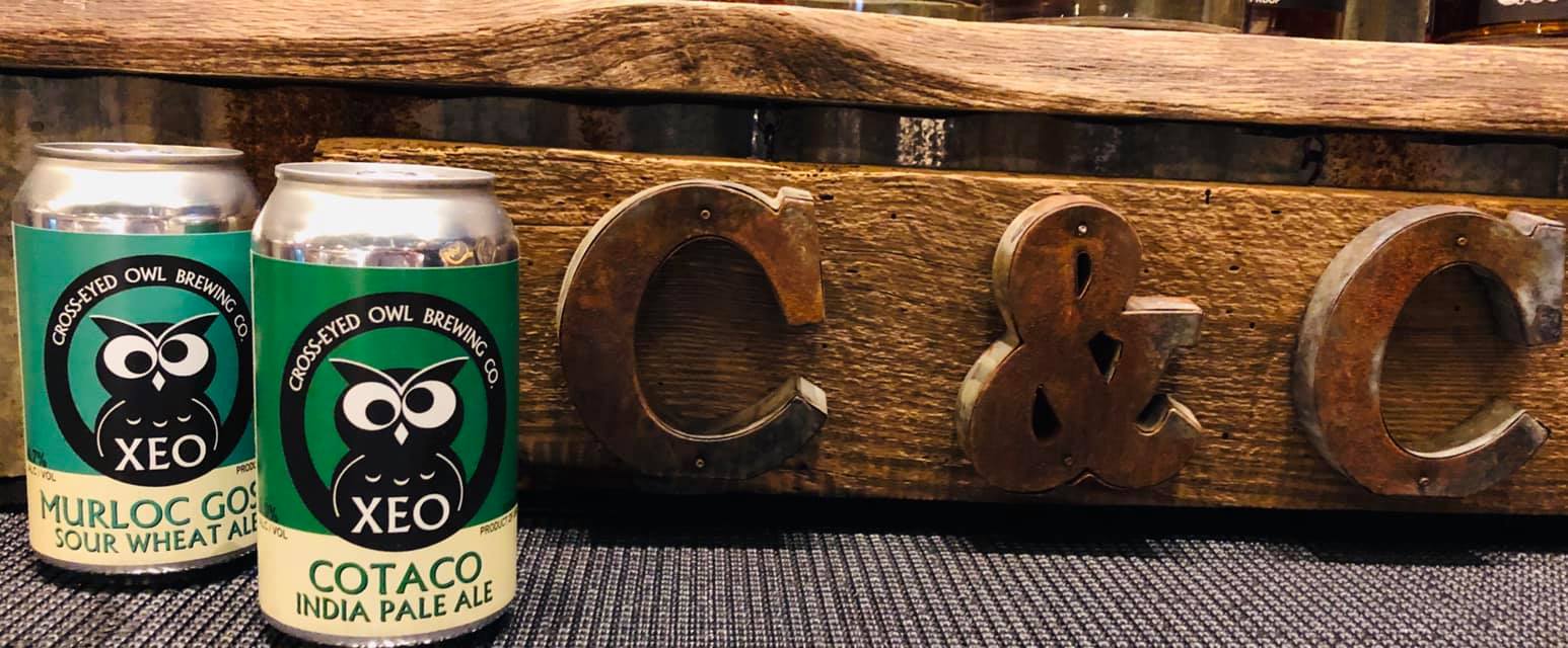 Two cans of beer are sitting next to each other on a table.