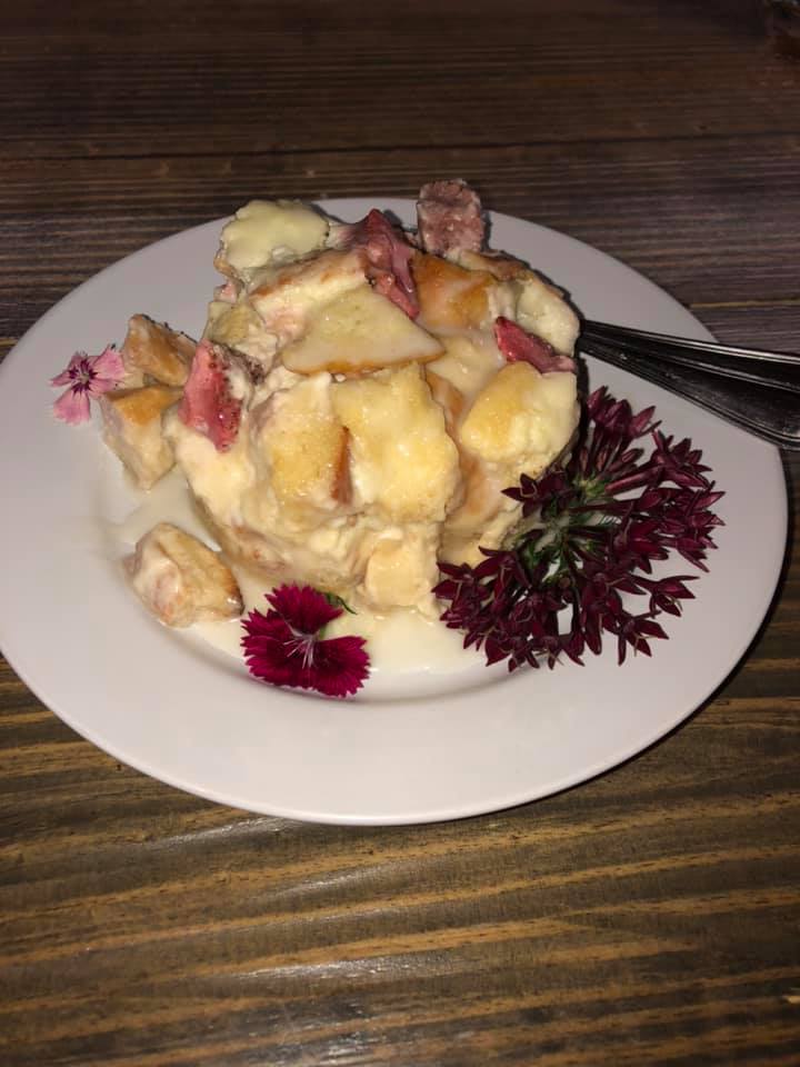 A plate of food with a fork on a wooden table.