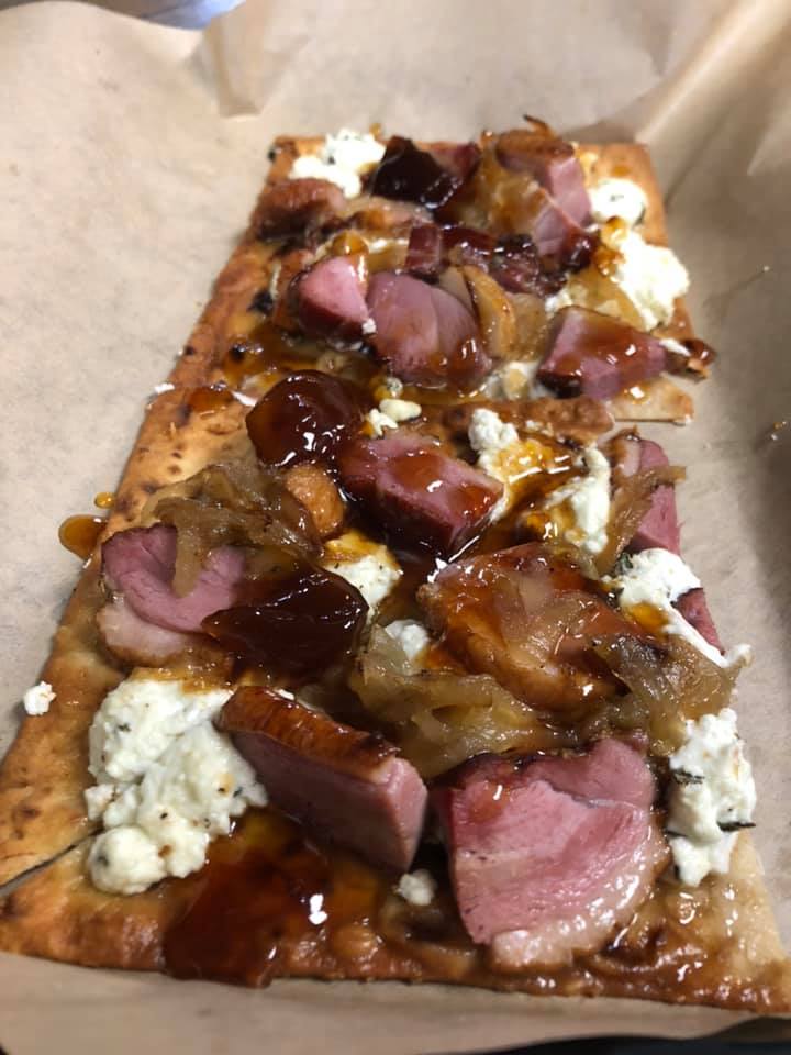 A slice of pizza with meat and cheese on it