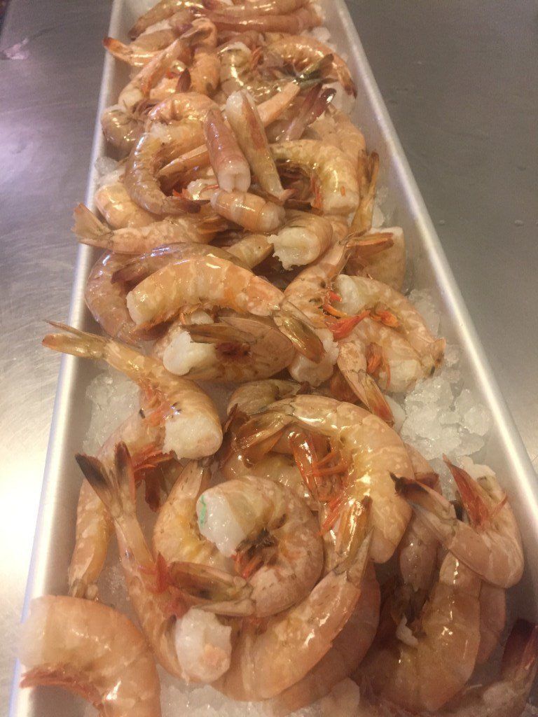 A tray of shrimp on ice on a table.