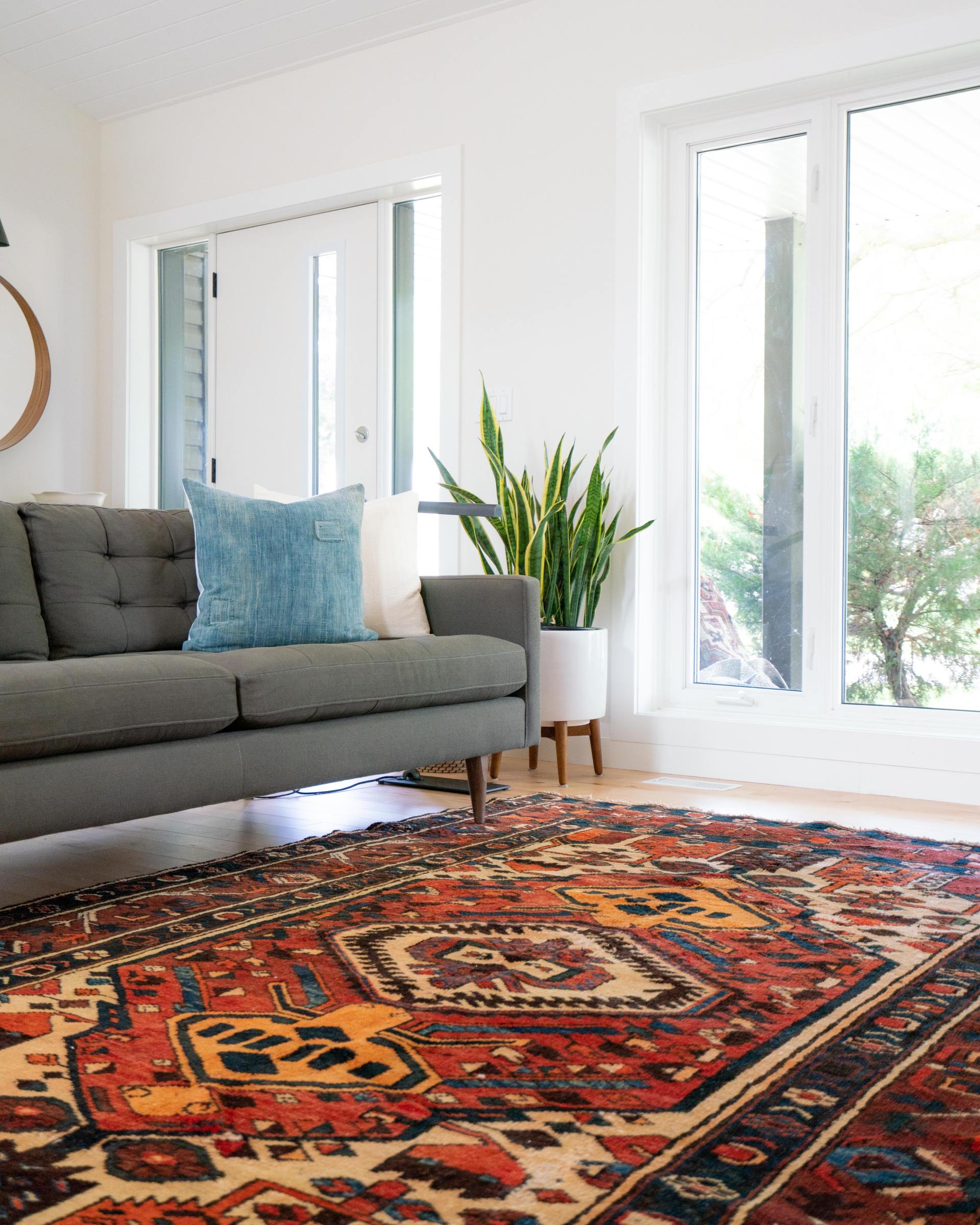 A living room with a couch and a rug on the floor.