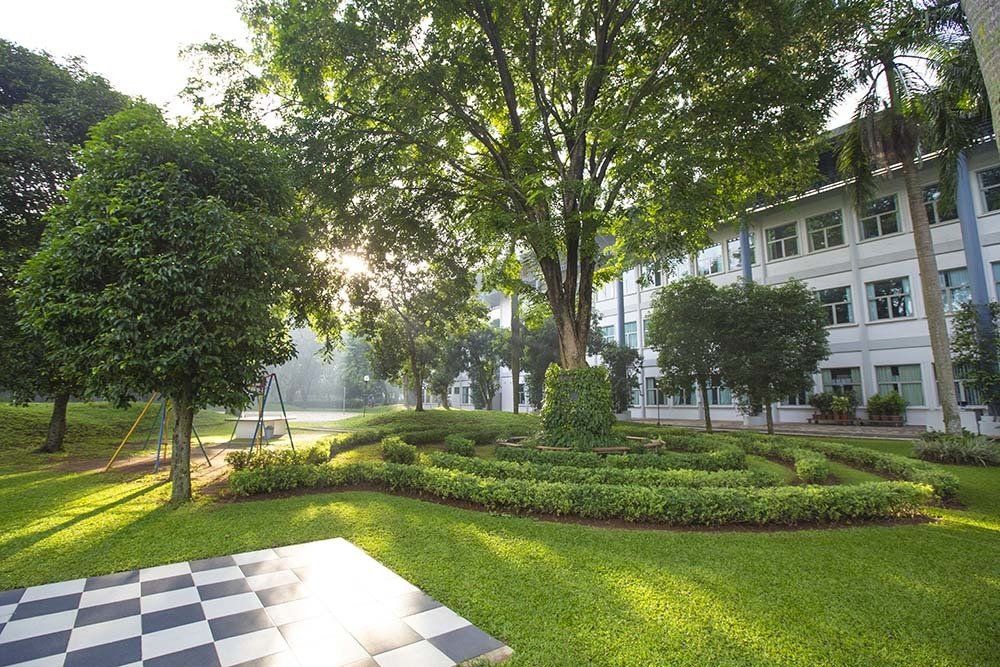 School building surrounded by a park with a chess field.