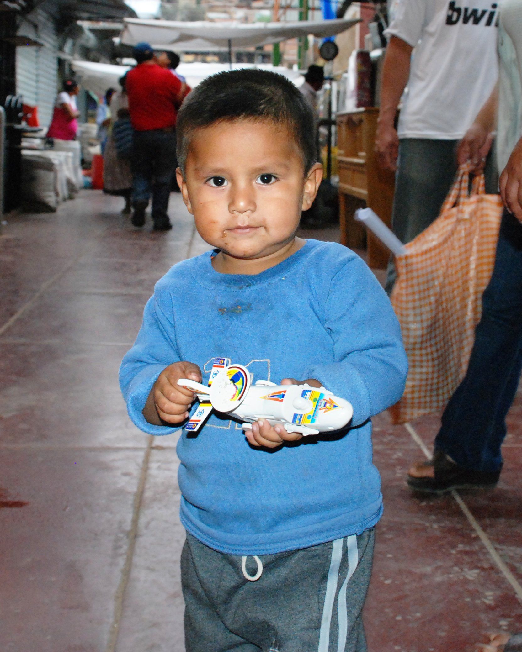 Boy with toy airplane in La Cancha, Bolivia.