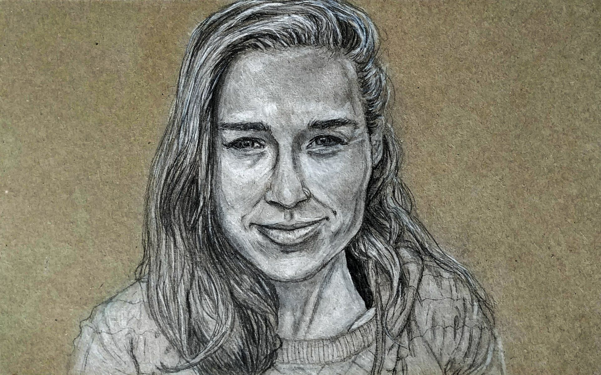 Charcoal drawing of a person smiling, long hair, and looking at the viewer.