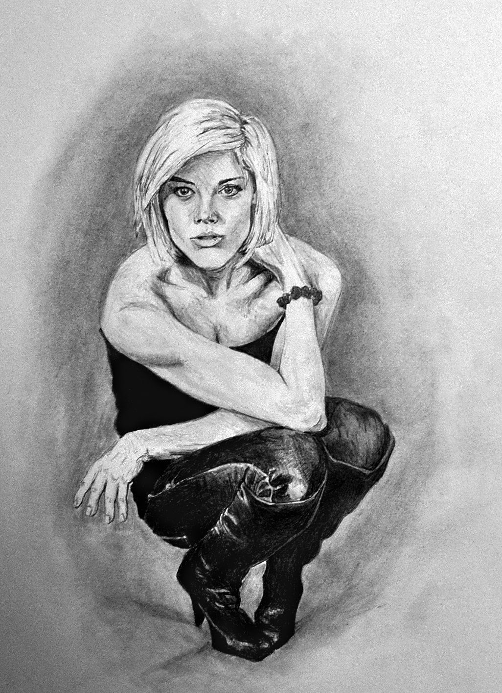 Blond woman, in black outfit, squats with arm resting on knee, looking towards viewer. Charcoal drawing.