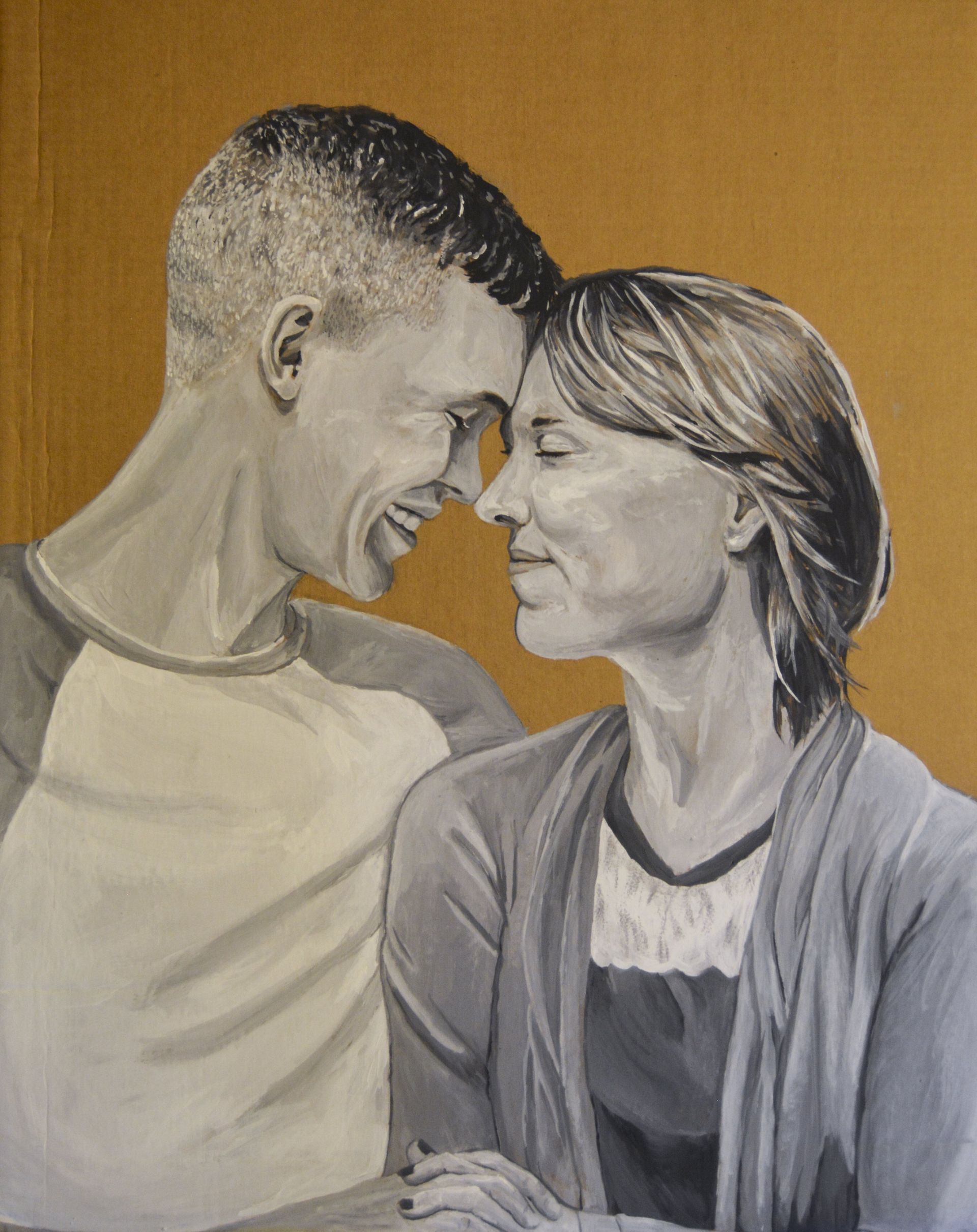 Couple, smiling, touching foreheads. Man in baseball tee, woman in cardigan. Gold background.