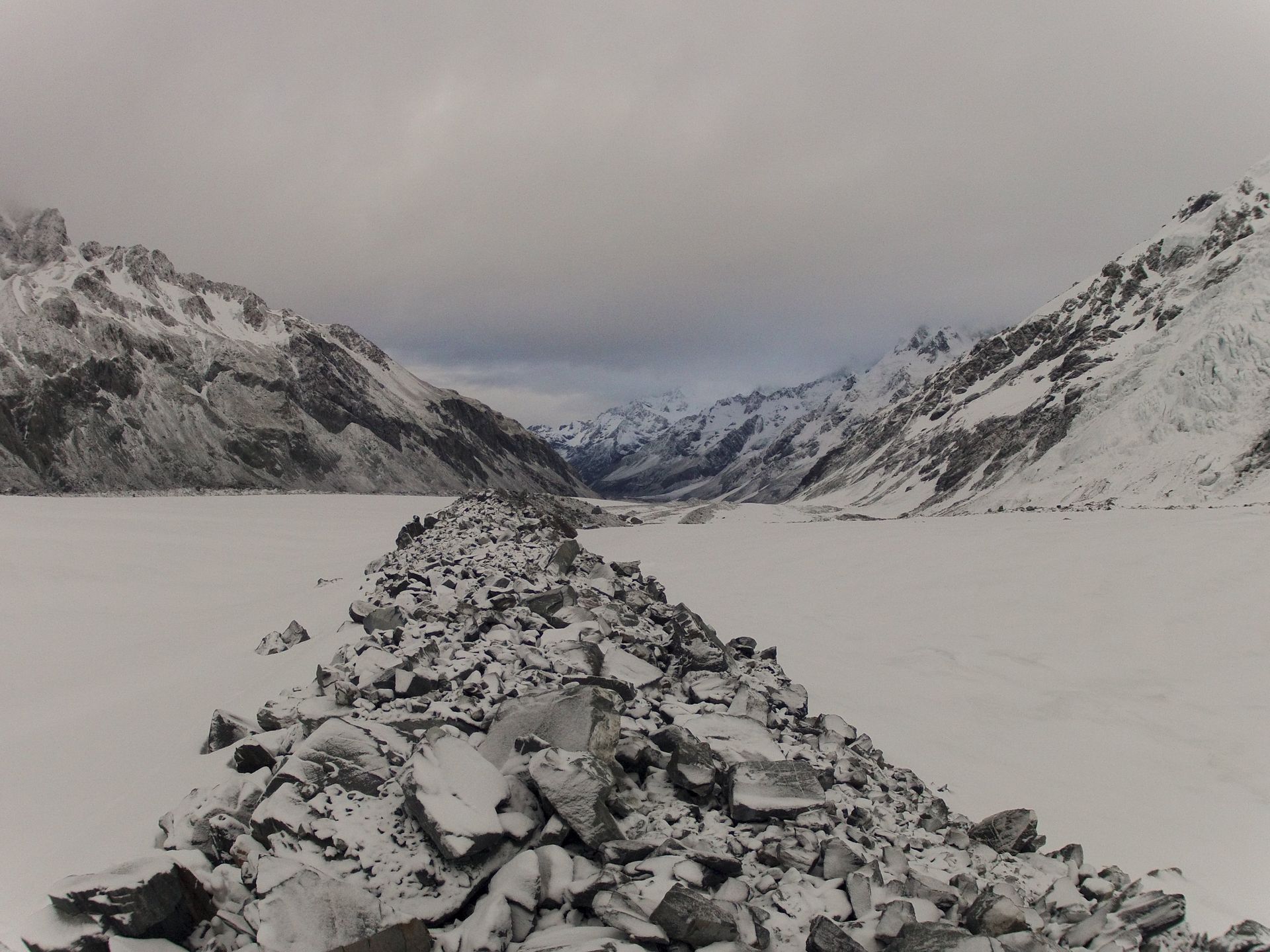 Snowy mountain landscape with a stone path leading into the distance.