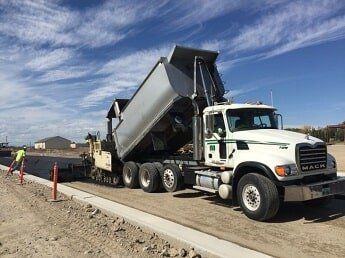 dump truck pours fresh asphalt - road construction in WY