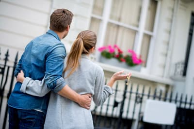 Residents standing in front of their new rental home