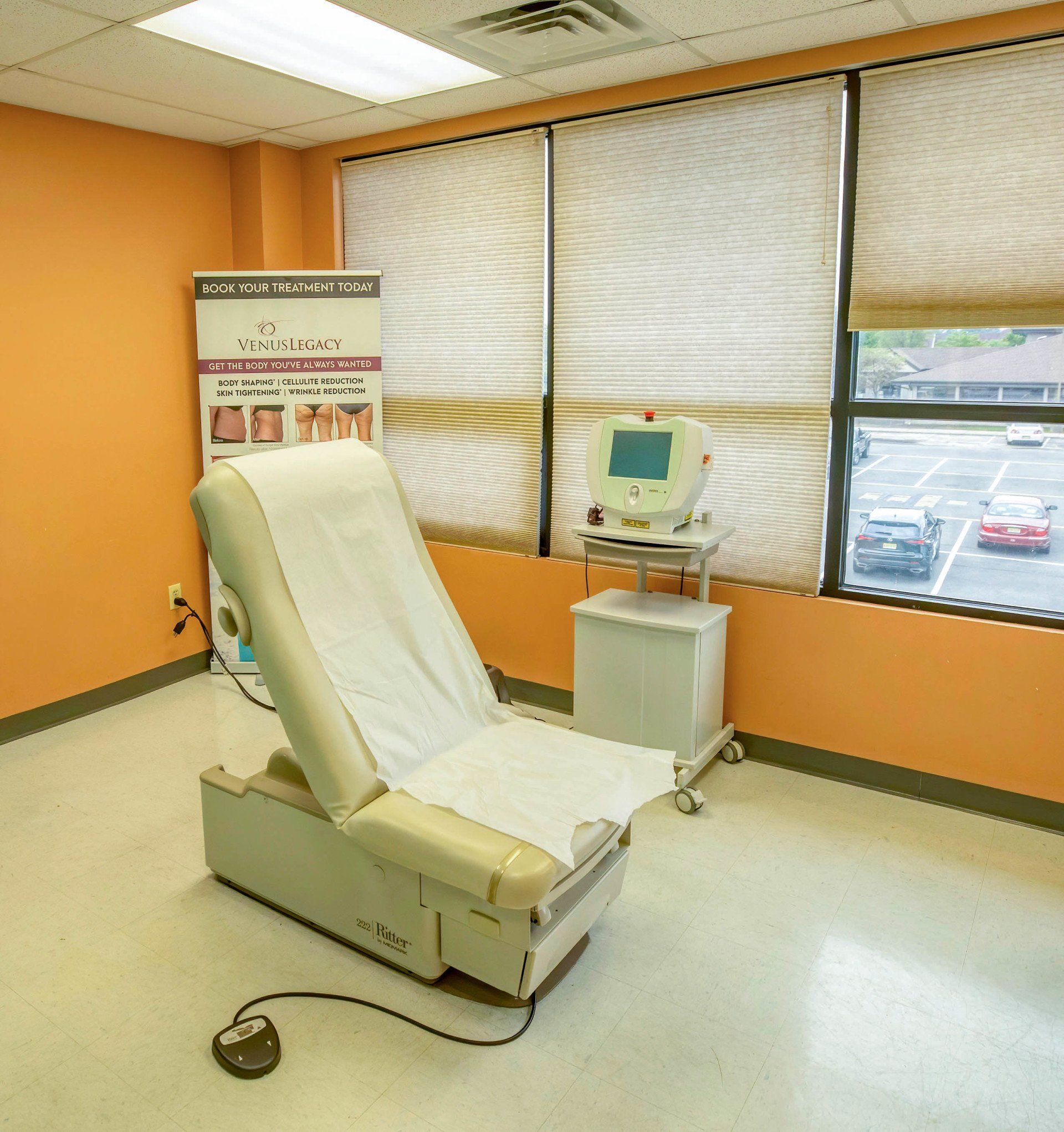 Medical examination room with an examination table, diagnostic equipment, and a window.