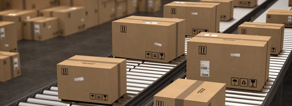 A conveyor belt filled with cardboard boxes in a warehouse.
