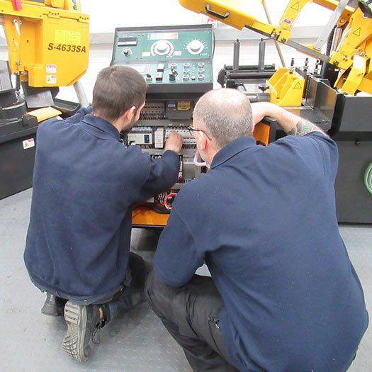 Two men are working on a machine that says s-453364 on it