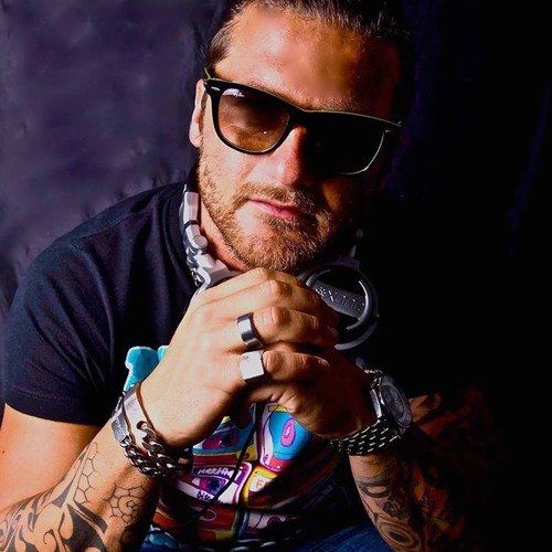 A man with a tattoo on his arm is wearing sunglasses and headphones