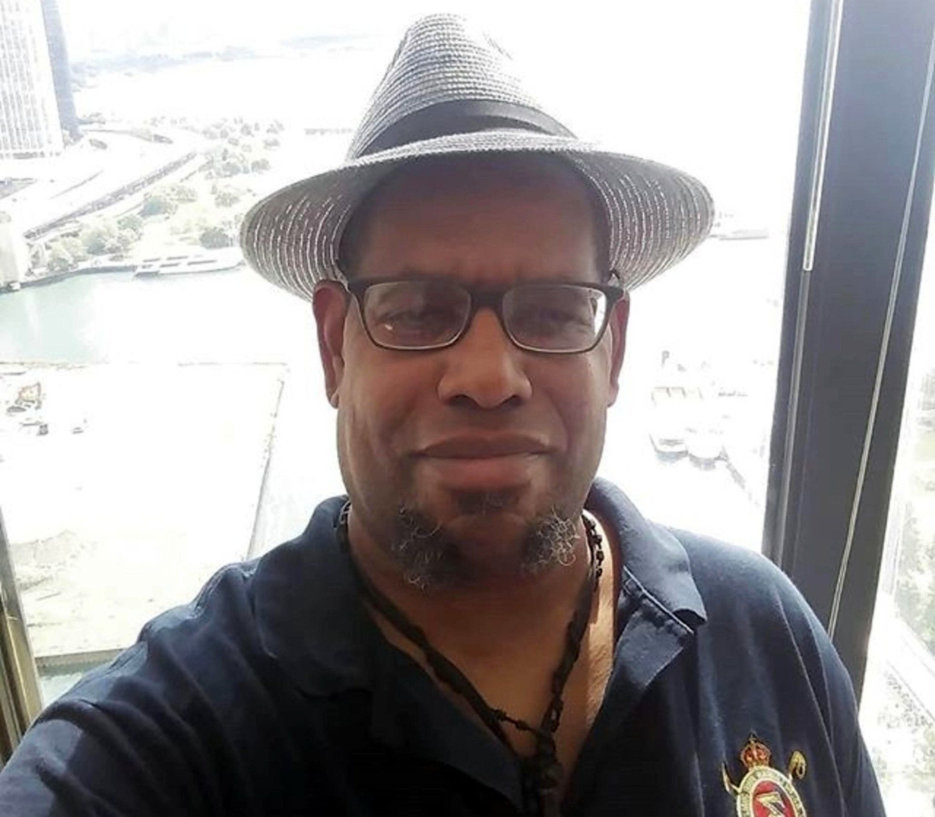 A man wearing a hat and glasses is taking a selfie
