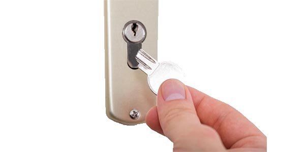 Photo of a hand holding a broken off key beside the lock