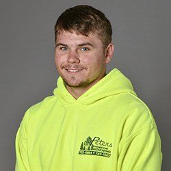 Man in a neon yellow hoodie smiling, logo