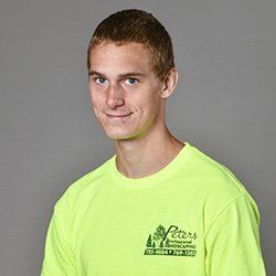 Young man in a neon yellow t-shirt, smiling, with text