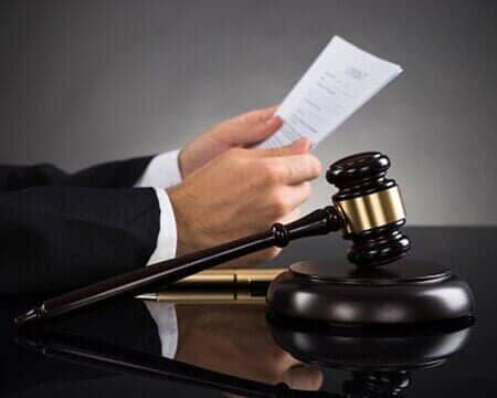 Lawyer Holding Document At Desk — Law Firm in Warren, PA Lawyer Holding Document At Desk — Law Firm in Warren, PA