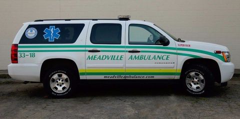 White Meadville Ambulance SUV with blue star-of-life emblem, shown in side view on pavement.