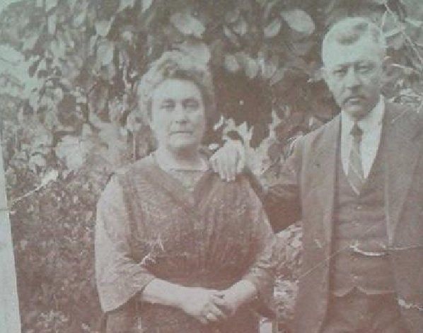 Twee mensen staan ​​buiten voor weelderig groen en poseren voor een vintage zwart-witfoto.