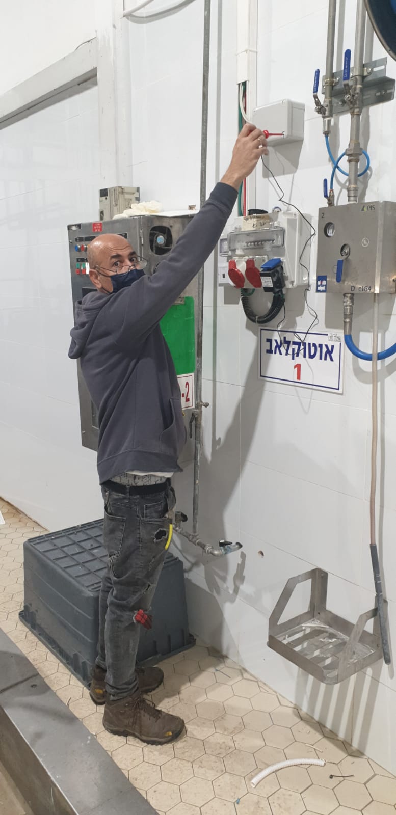 אדם עובד על מכונה בחדר.