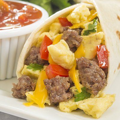 Beef and scrambled egg breakfast taco with peppers and cheese, served with salsa in a cup