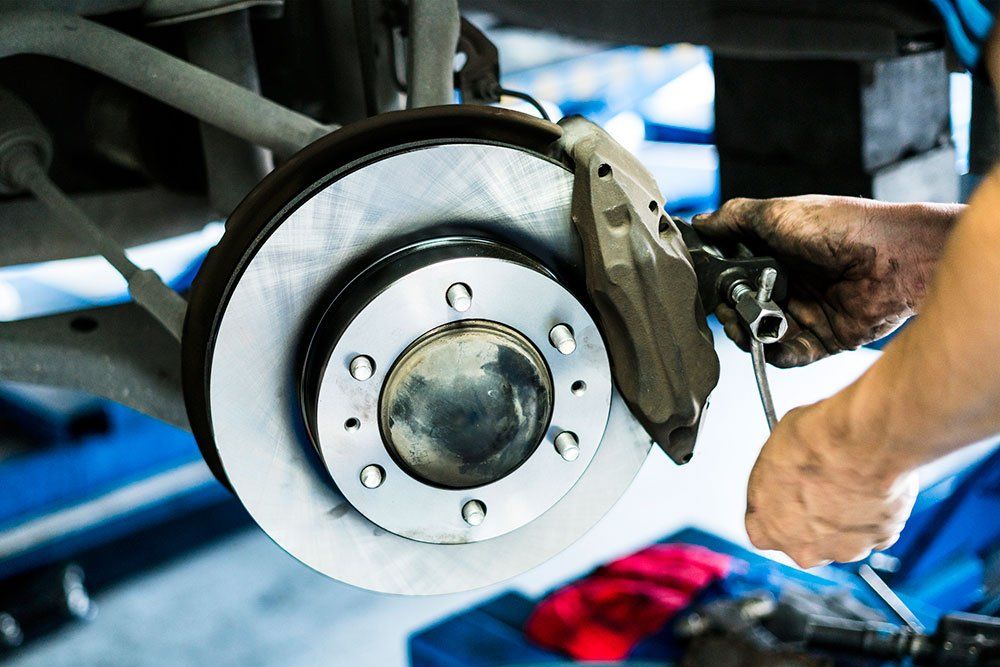 a man is working on a brake disc on a car
