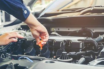 a man is working on the engine of a car in a garage .
