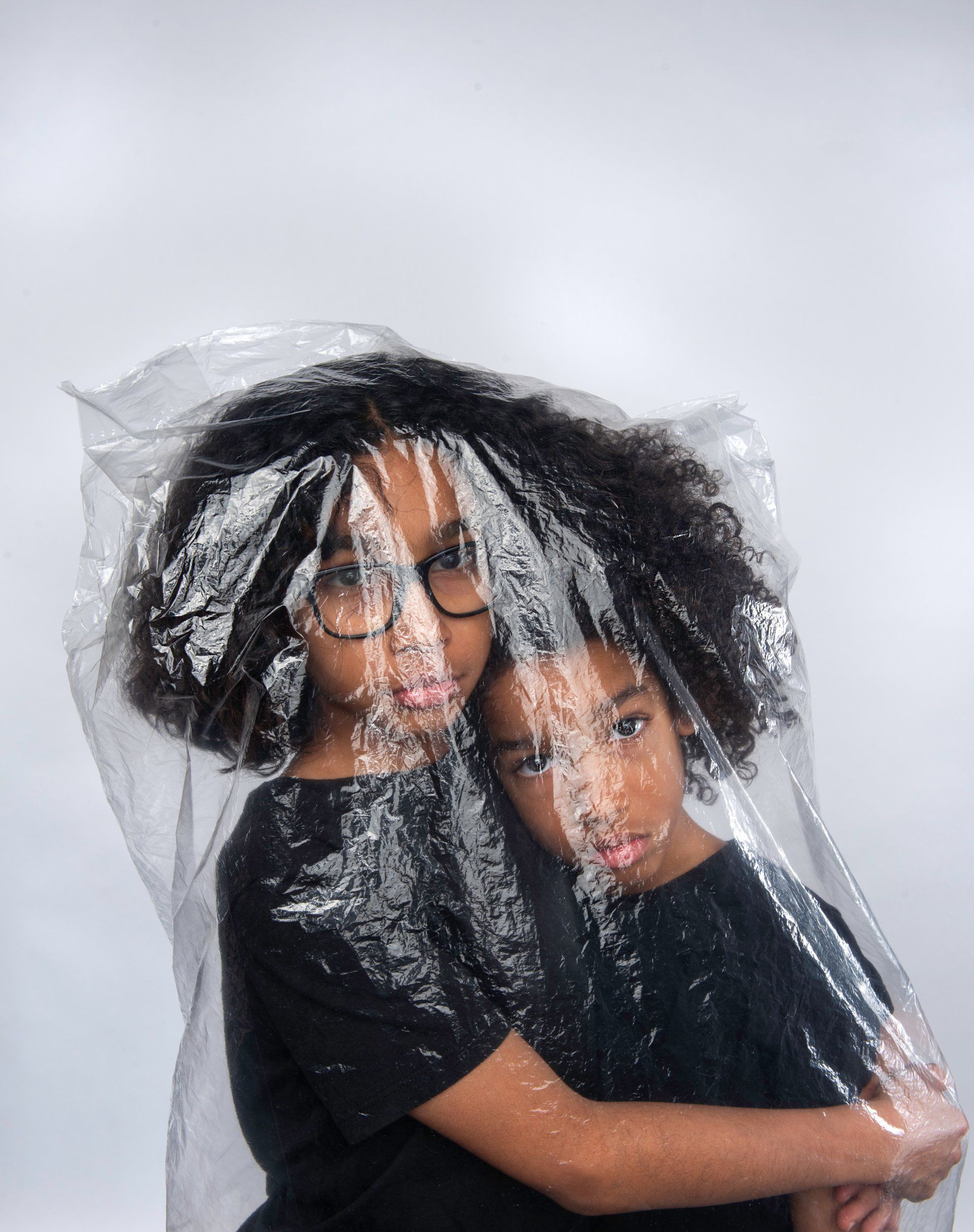 Two people hugging inside a clear plastic bag.