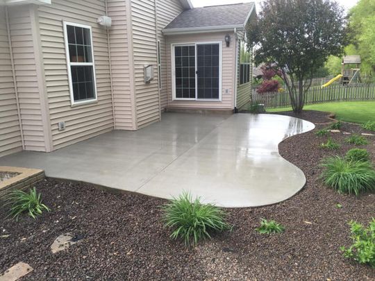 There is a patio in the backyard of a house.