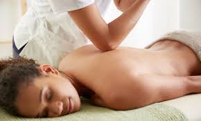 Person receiving a back massage on a table in a spa setting