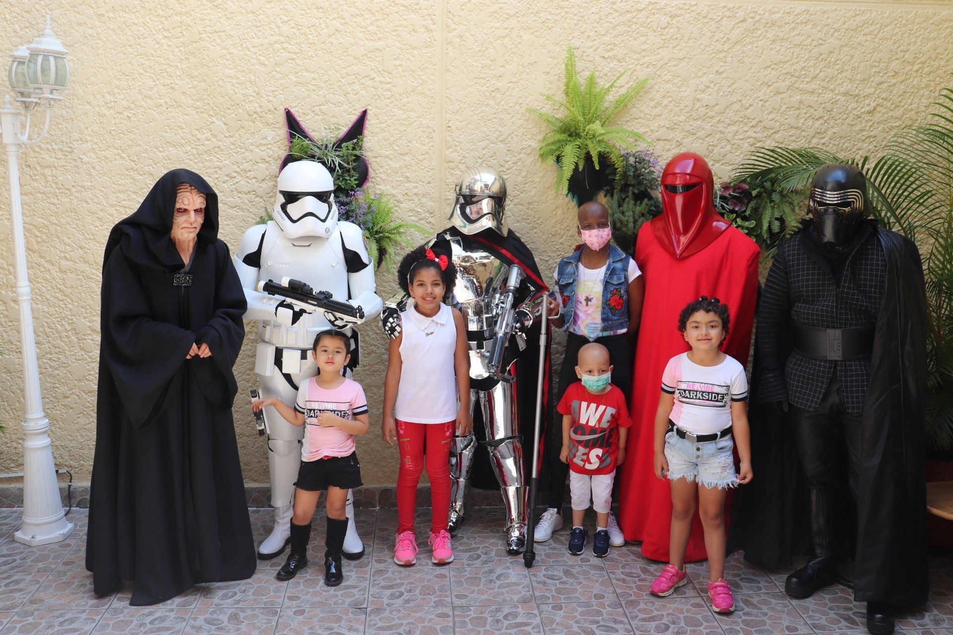 Niños y personajes de Star Wars posan juntos al aire libre.