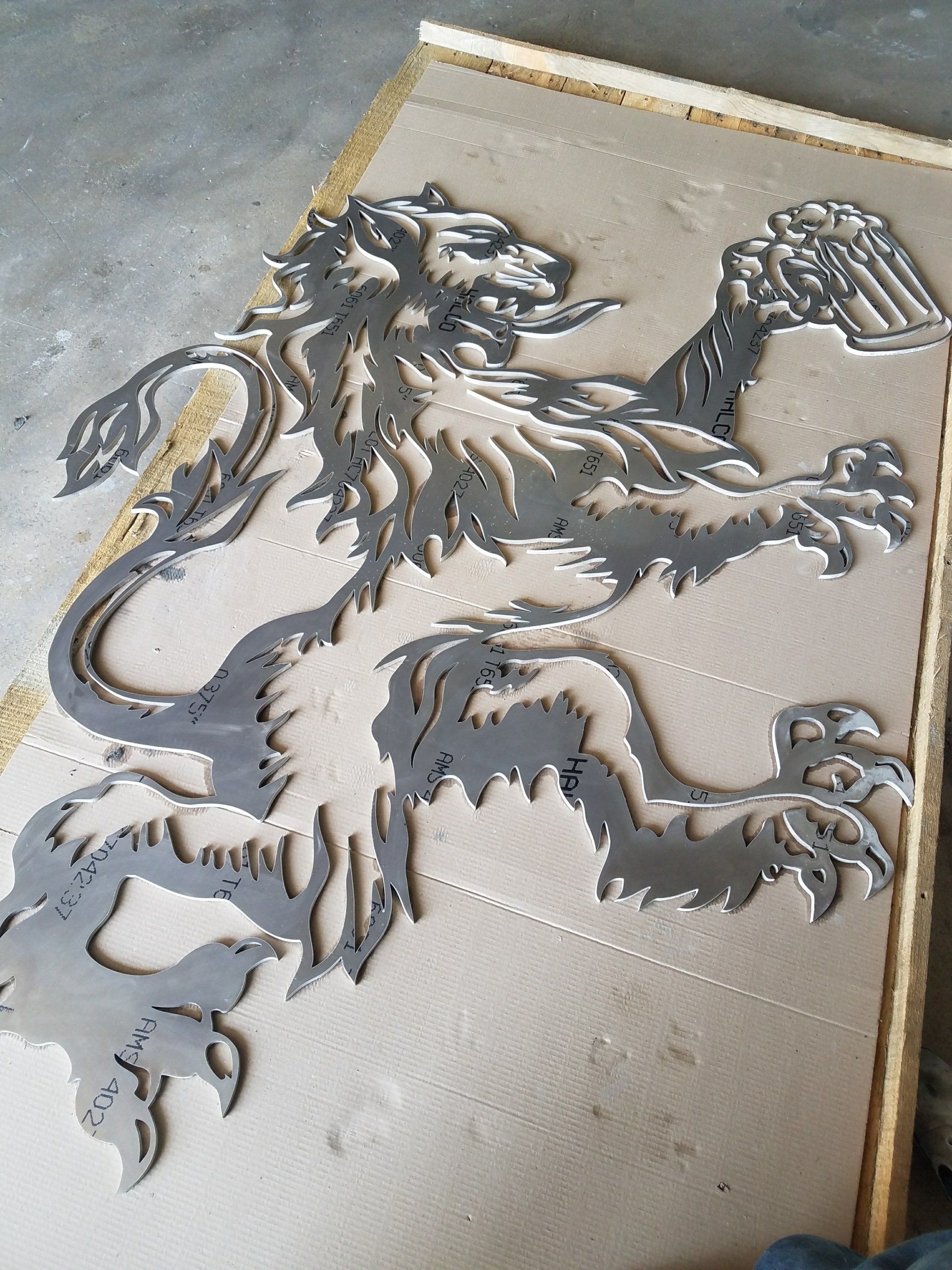 A metal lion is sitting on a piece of cardboard