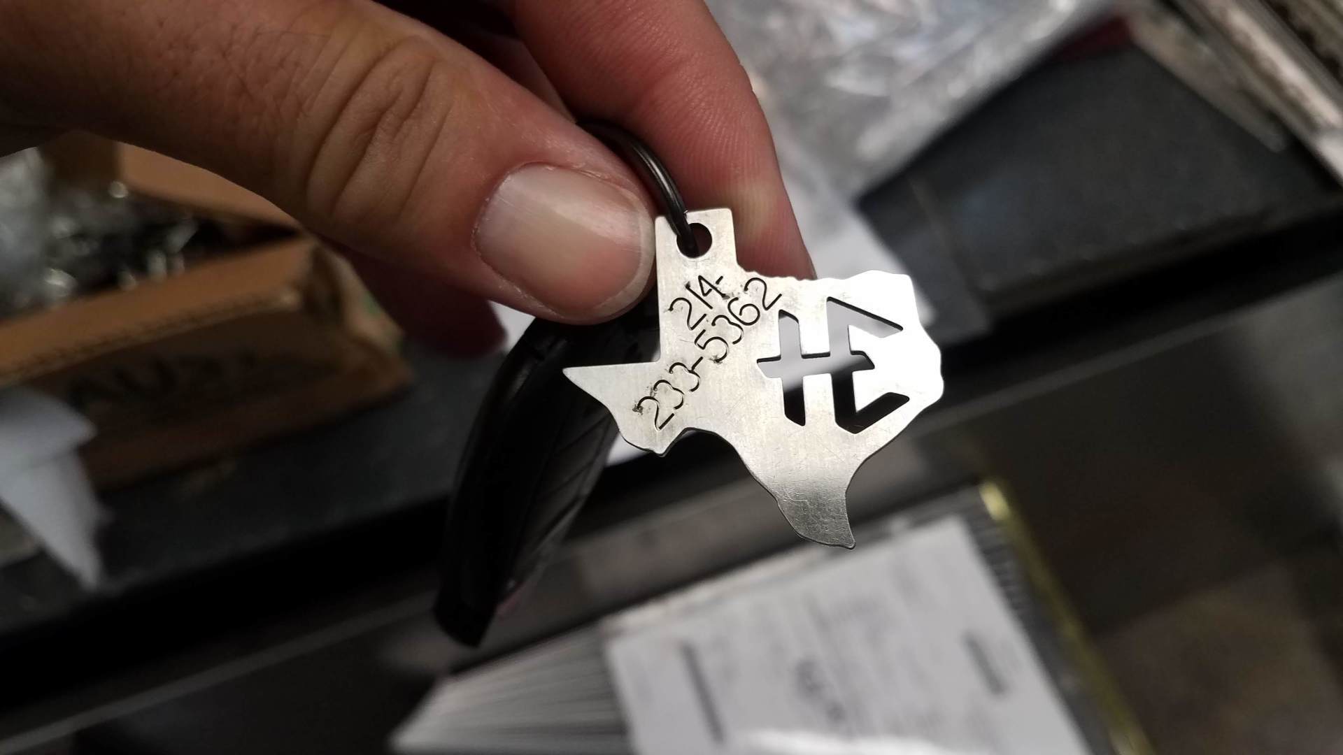 A person is holding a texas keychain in their hand