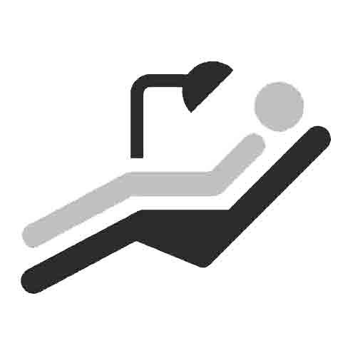 man laying in chair at dentist icon