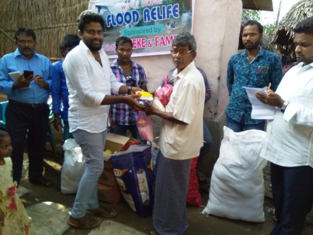 Mensen delen hulpgoederen uit aan slachtoffers van de overstromingen. Flood Relief in het vissersdorp in India.