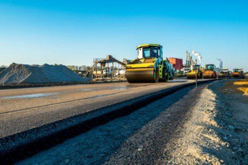 Man's legs on newly laid asphalt during road construction — Asphalt Service in West Bend, WI