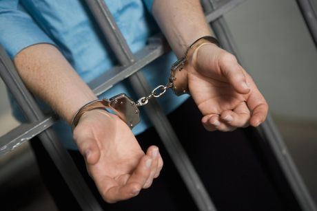 unrecognized person inside the jail with handcuffs