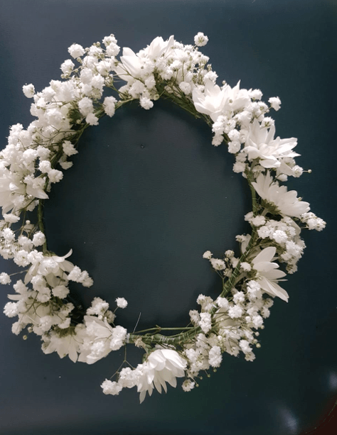 Una corona de flores blancas sobre un fondo azul.