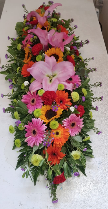 Un ramo de flores de colores están sobre una mesa.