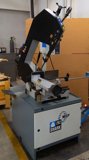 Una sega a nastro è appoggiata su un tavolo in un'officina.