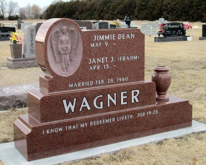 A unique companion monument in all polished red granite with recessed relief angel carving and a match turned vase