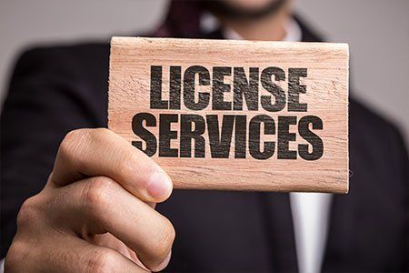 Man Holding A Piece Of Wood With License Services Word — Los Angeles, CA — Spiga and Associates Man Holding A Piece Of Wood With License Services Word — Los Angeles, CA — Spiga and Associates