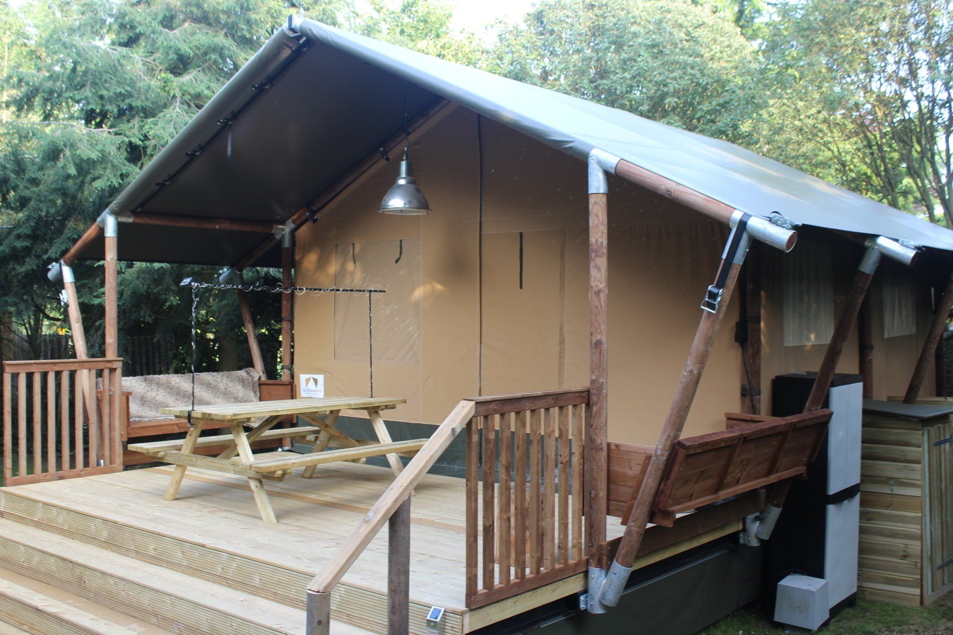 Een tent met een picknicktafel op de veranda.