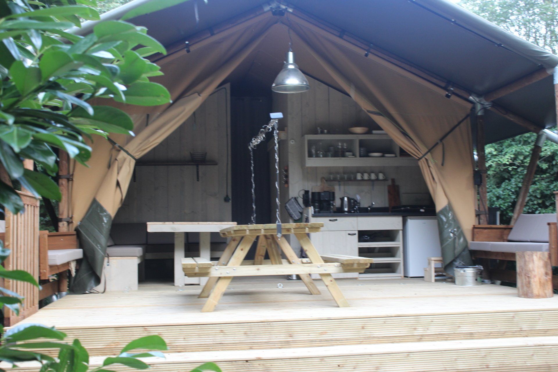 Een tent met een picknicktafel ervoor