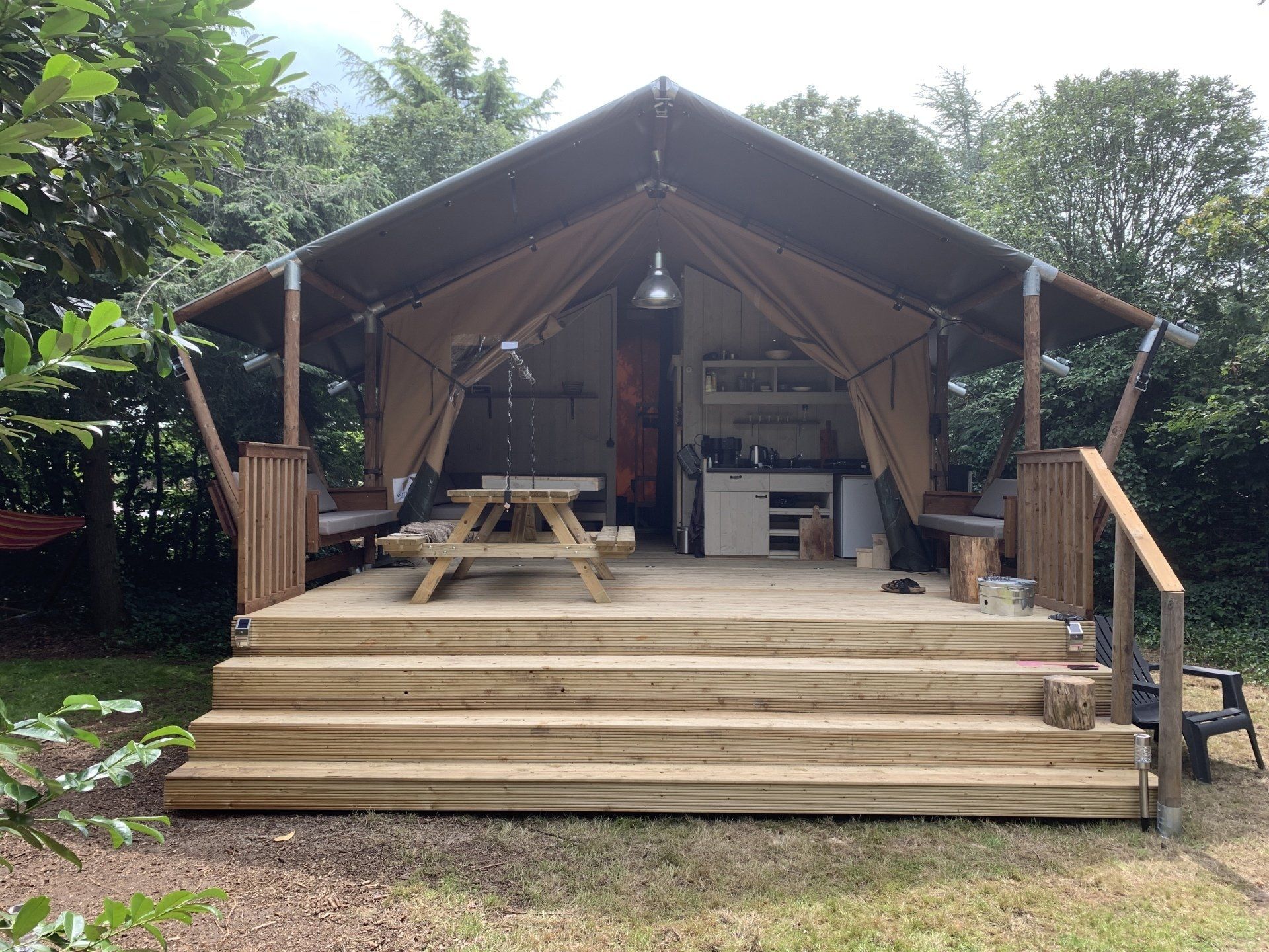 Een tent met een picknicktafel en een trap ervoor