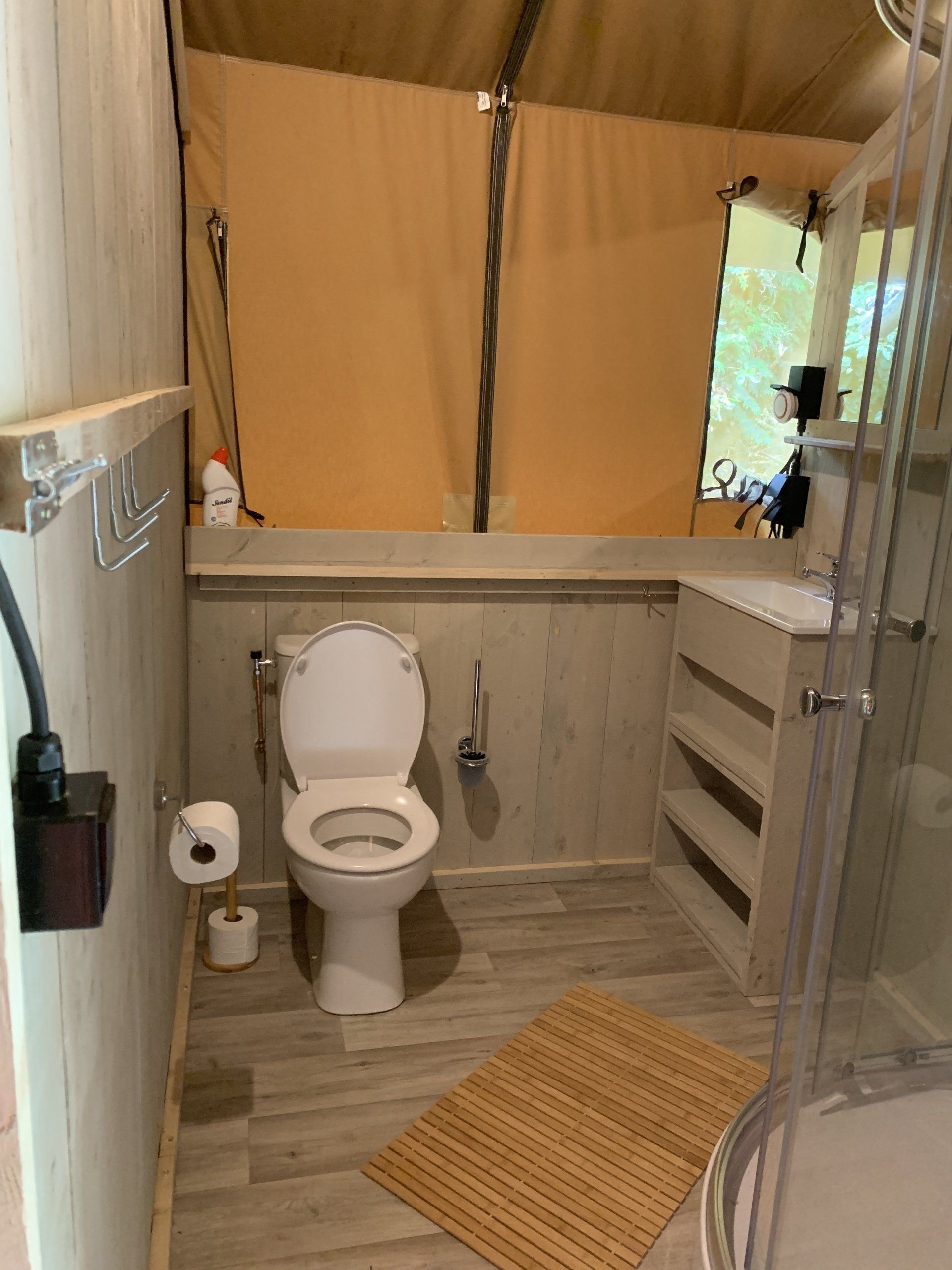 Een badkamer met toilet, wastafel en douche.