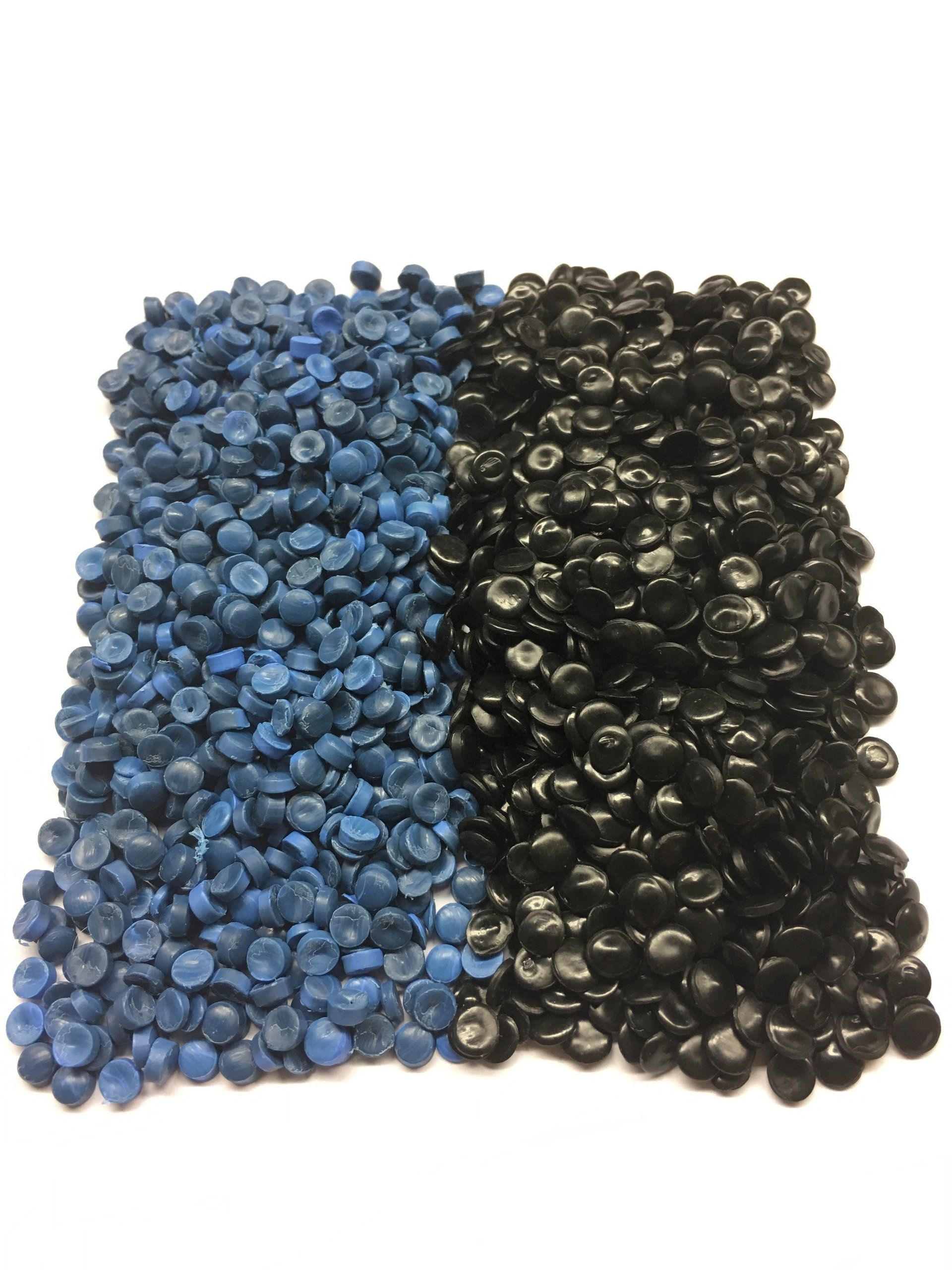 A pile of blue and black plastic granules on a white surface